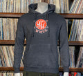 Gray hoodie with a logo on a mannequin in front of a record album shelf