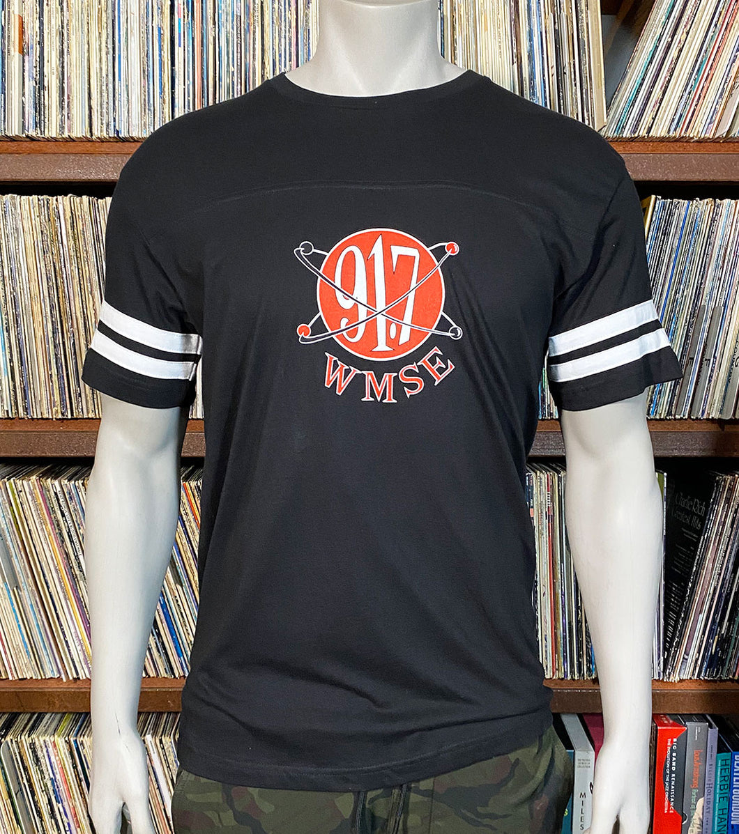 Black t-shirt with red and white logo on a mannequin against a record album background