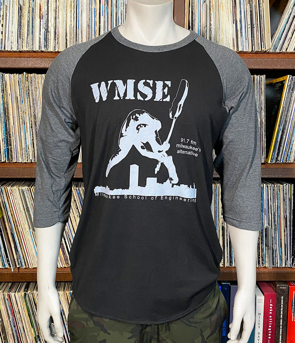 Black and gray baseball shirt with 'WMSE' logo on a mannequin in front of a recordshelf.