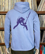 Load image into Gallery viewer, Light blue hoodie with a purple graphic on the back, worn by a person in front of a bookshelf.